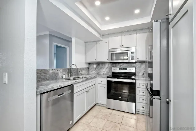 a kitchen with stainless steel appliances granite countertop a stove sink and refrigerator