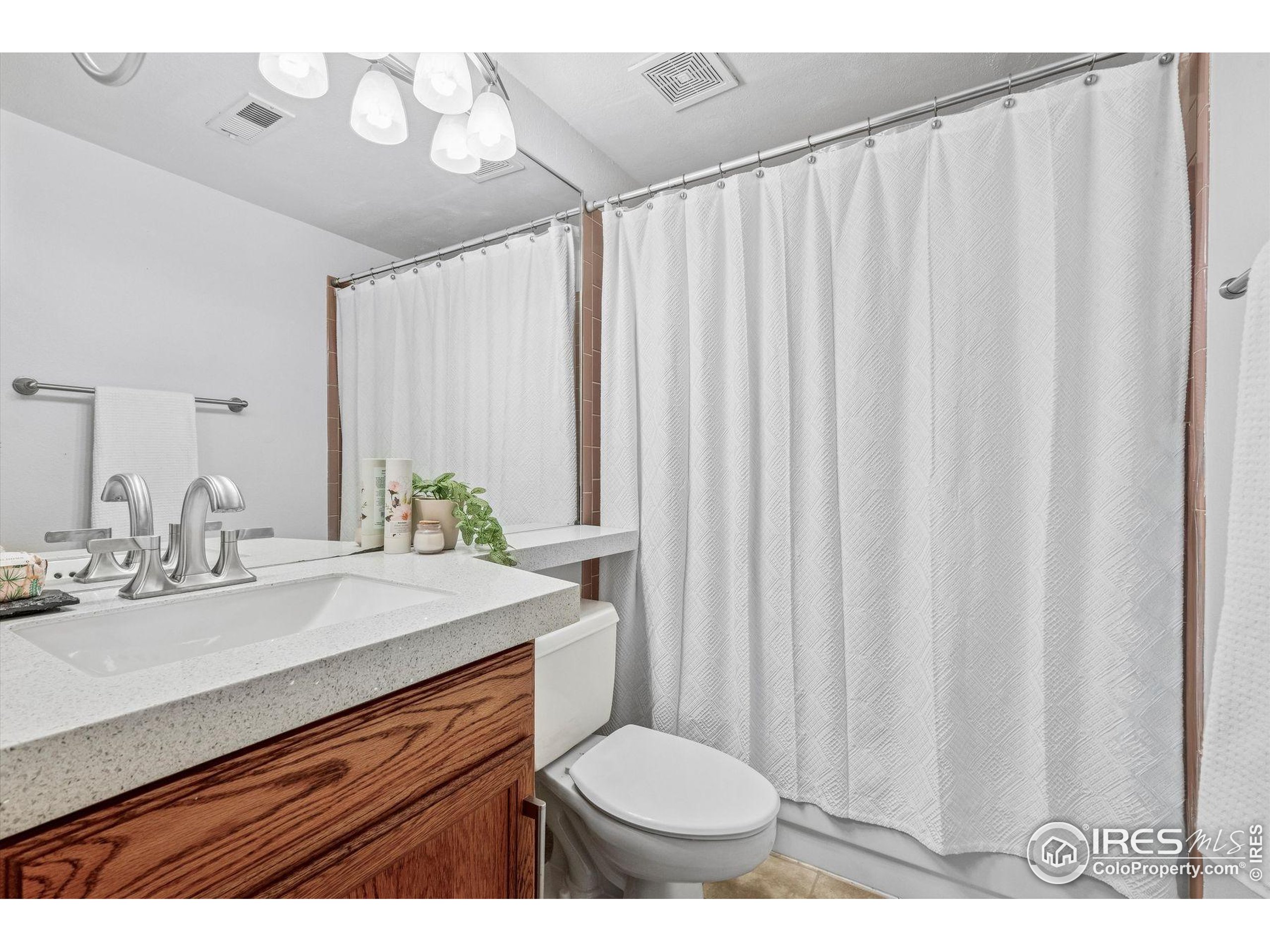4541 Ensenada Street Denver, CO 80249 - Photo 25 of 35 a bathroom with a sink vanity mirror and toilet