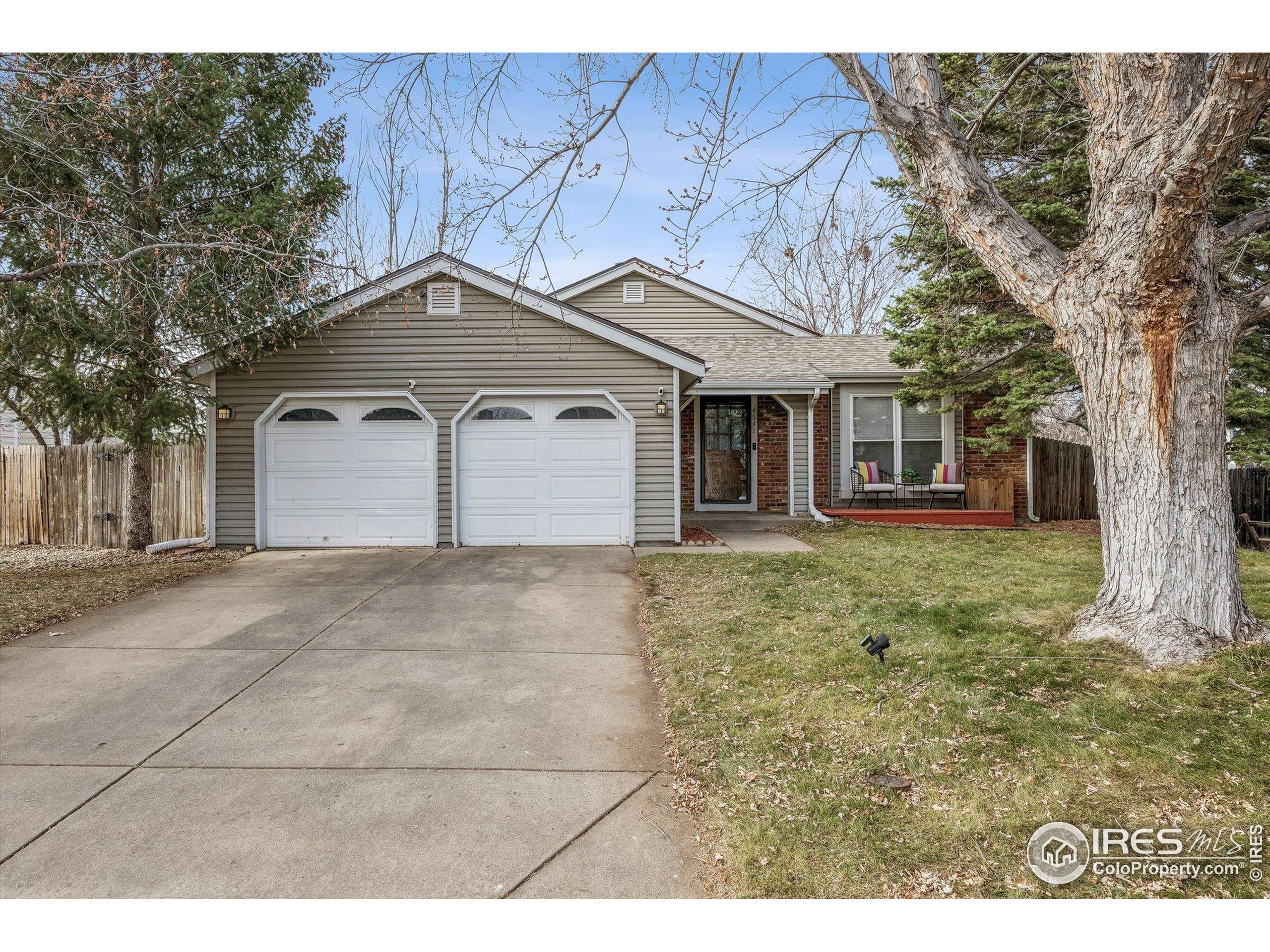 4541 Ensenada Street Denver, CO 80249 - Photo 7 of 35 a front view of a house with a garden and trees