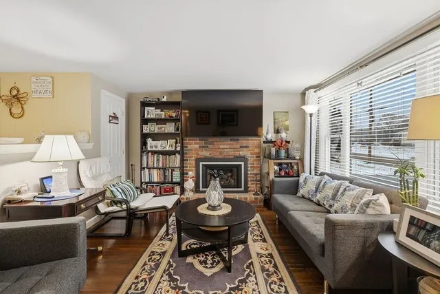 a living room with furniture a flat screen tv and a fireplace