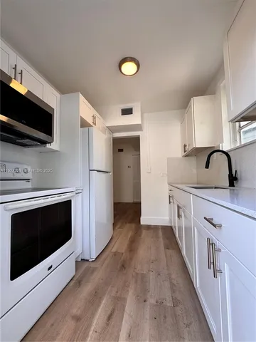 a kitchen with stainless steel appliances a stove microwave and sink