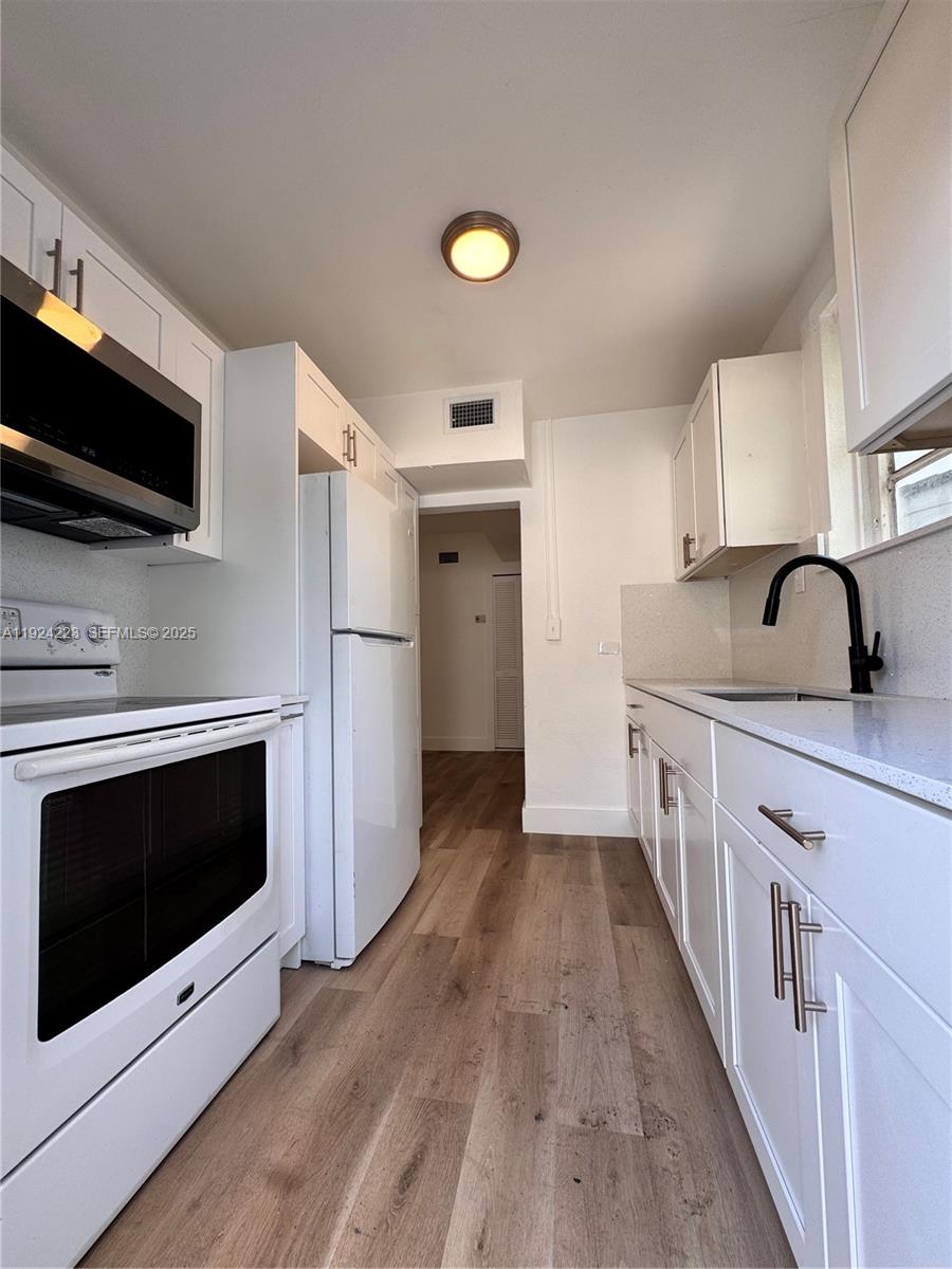 2381 Northwest 153rd Street, Unit 2381 Miami Gardens, FL 33054 - Photo 3 of 5 a kitchen with stainless steel appliances a stove microwave and sink