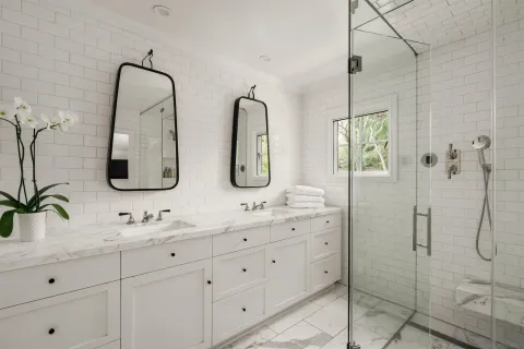 a bathroom with double vanity sinks and a mirror