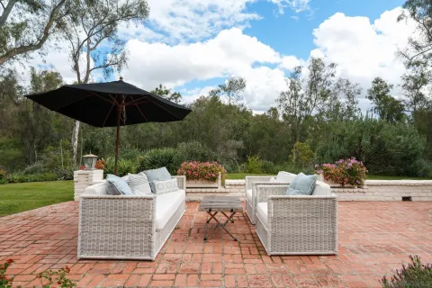 a view of a patio with couches and table under an umbrella