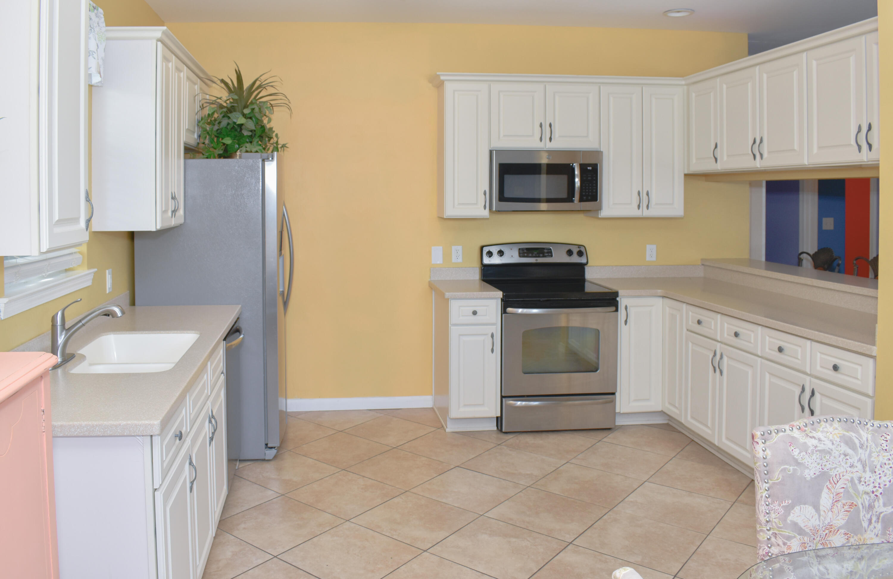4455 Luke Avenue Destin, FL 32541 - Photo 16 of 44 a kitchen with granite countertop white cabinets and stainless steel appliances