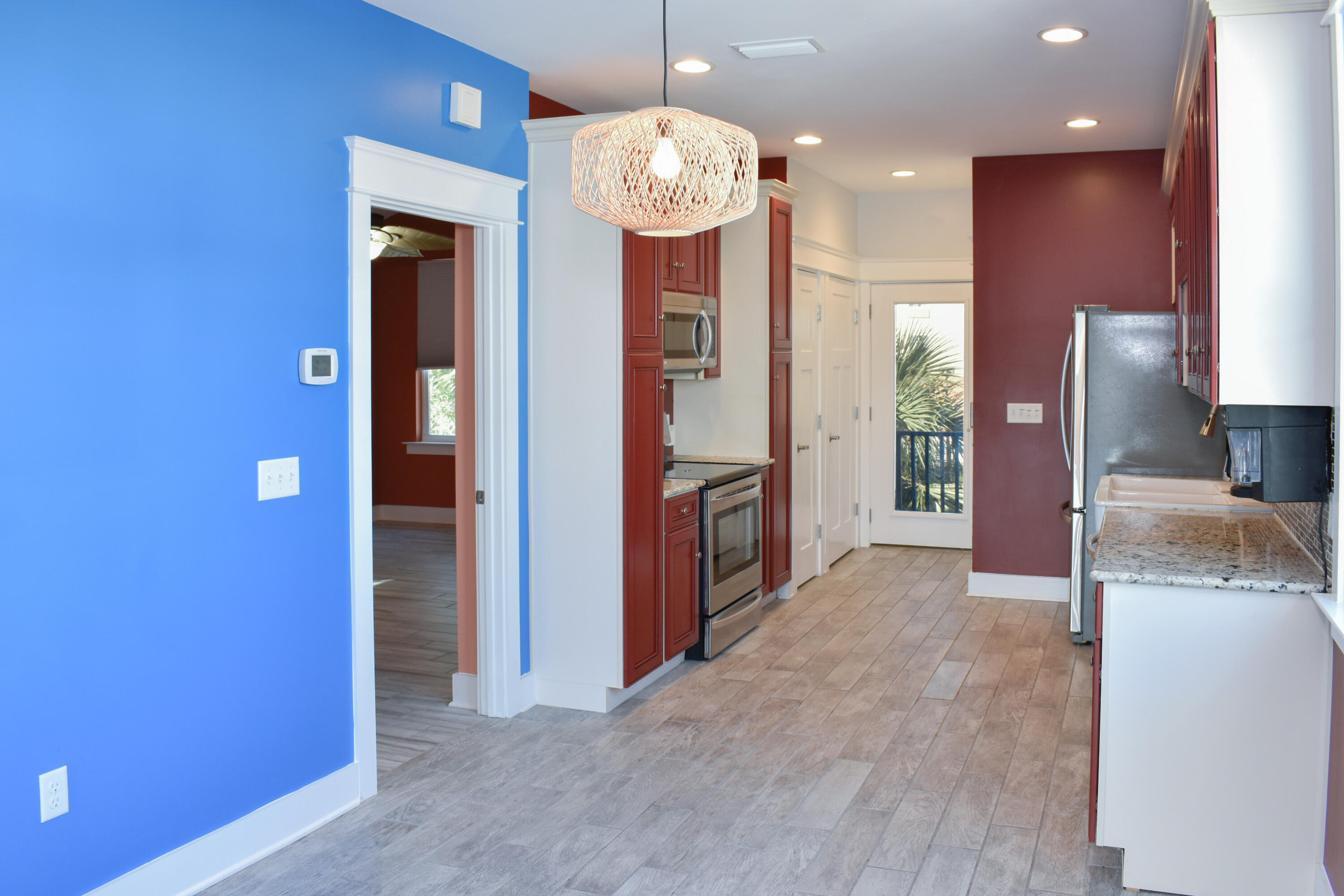 4455 Luke Avenue Destin, FL 32541 - Photo 38 of 44 an empty room with kitchen view and wooden floor