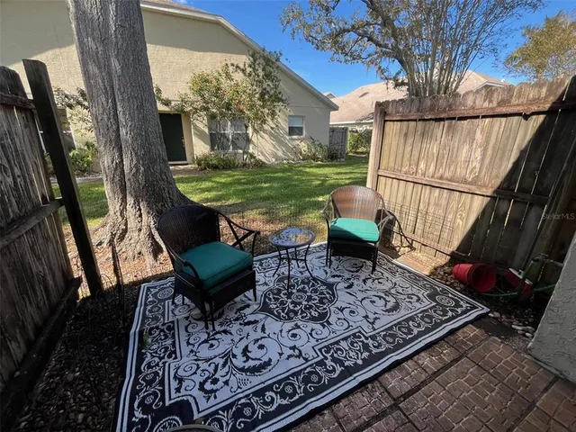 a view of a chairs and table in back yard of a house