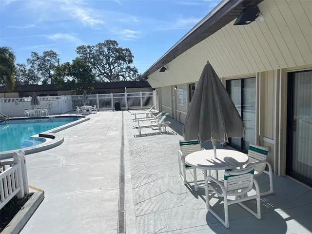 a view of a swimming pool with a patio and a yard