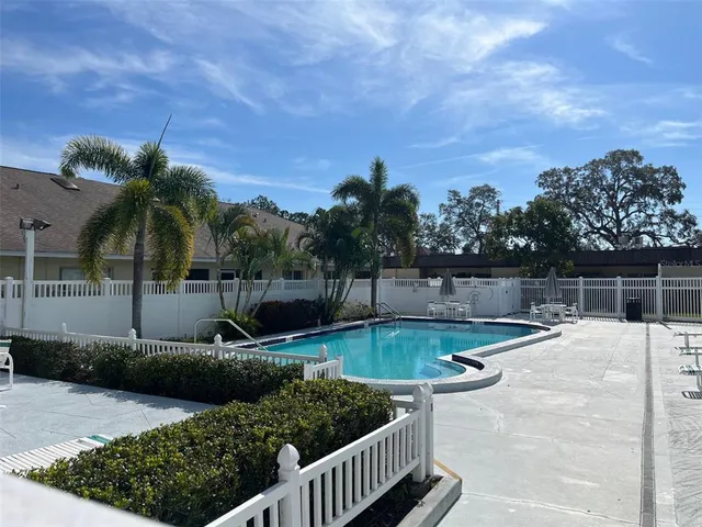 a view of a house with pool and chairs