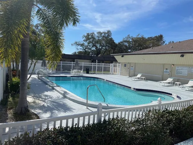 a view of a house with pool and chairs
