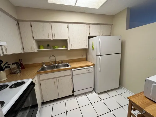 a kitchen with a sink a stove and white refrigerator
