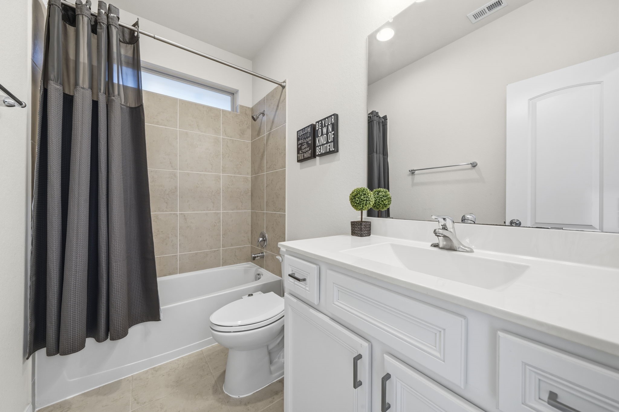 16731 Doubletree Ranch Drive Cypress, TX 77433 - Photo 6 of 44 Full bathroom with a clean design featuring a shower/tub combo with a tiled surround, white vanity with storage, large mirror, and durable tile flooring.