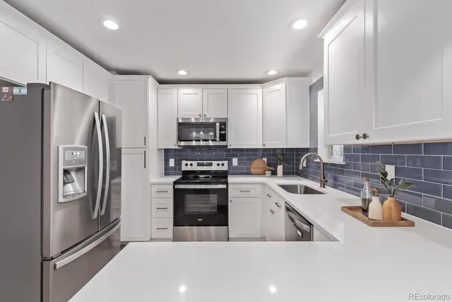a kitchen with stainless steel appliances a refrigerator sink and microwave
