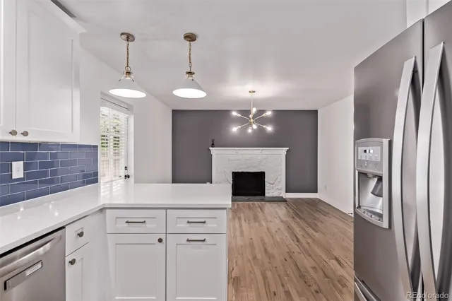 a kitchen with stainless steel appliances granite countertop a refrigerator a sink and a stove