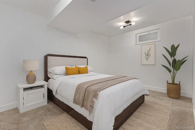 a bedroom with a large bed and a potted plant