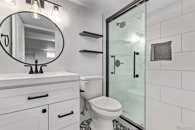 a bathroom with a toilet a sink and mirror