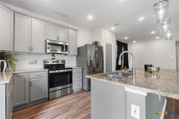 a kitchen with stainless steel appliances granite countertop a sink stove and refrigerator