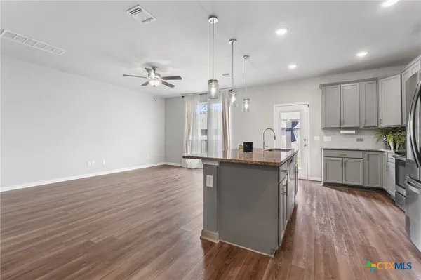 a kitchen with kitchen island a sink stainless steel appliances and cabinets
