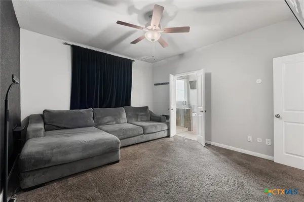 a living room with furniture and a ceiling fan