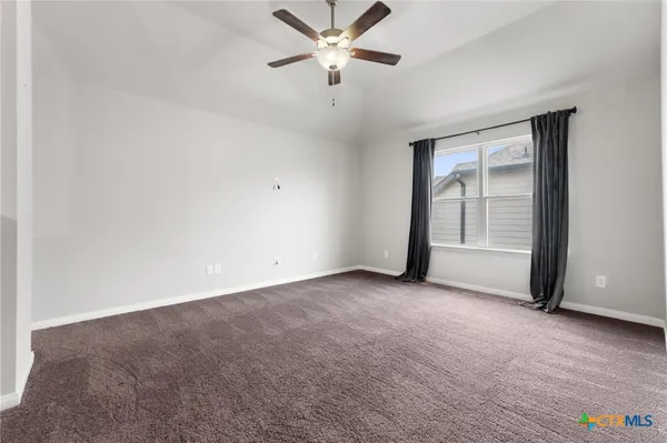 an empty room with closet and a ceiling fan