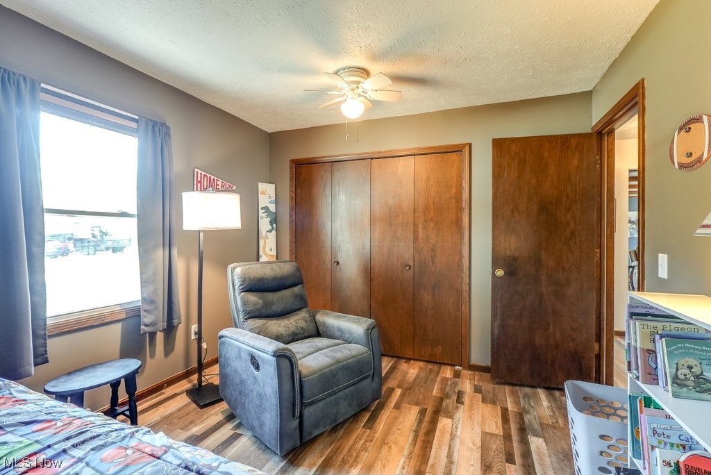 1157 Bass Circle Northwest Canton, OH 44708 - Photo 16 of 31 Bedroom featuring a ceiling fan, wood finished floors, a closet, and a textured ceiling