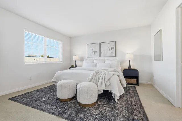 a bedroom with a bed and painting on the wall