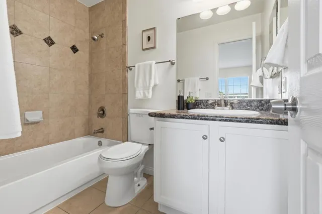 a bathroom with a granite countertop sink a toilet and a bathtub