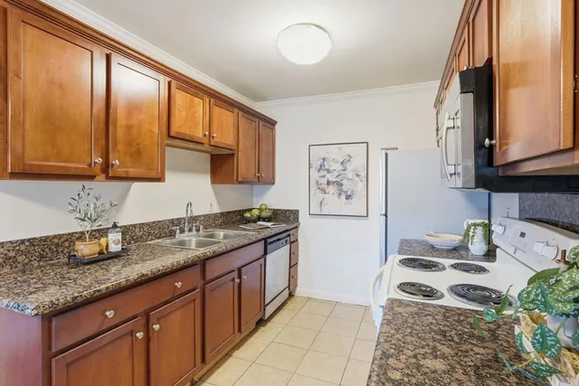 a kitchen with stainless steel appliances granite countertop a stove a sink and a microwave