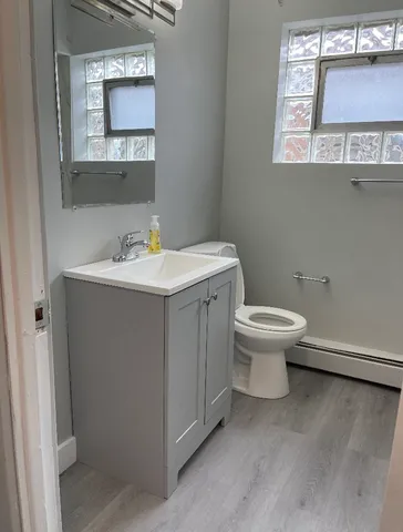 a bathroom with a toilet sink and mirror