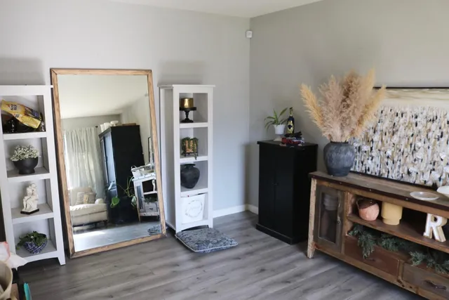 a view of a hallway with wooden floor and a living room