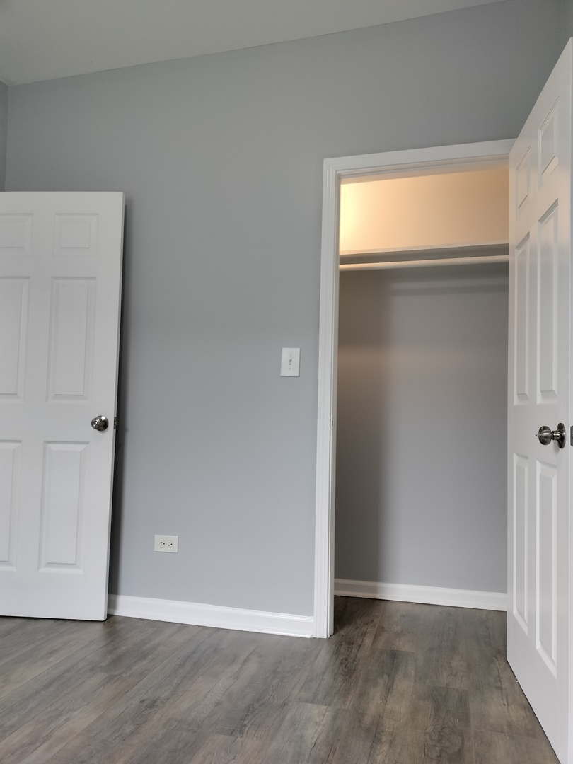 6601 South Green Street, Unit 8211 Chicago, IL 60621 - Photo 11 of 12 an empty room with wooden floor and closet