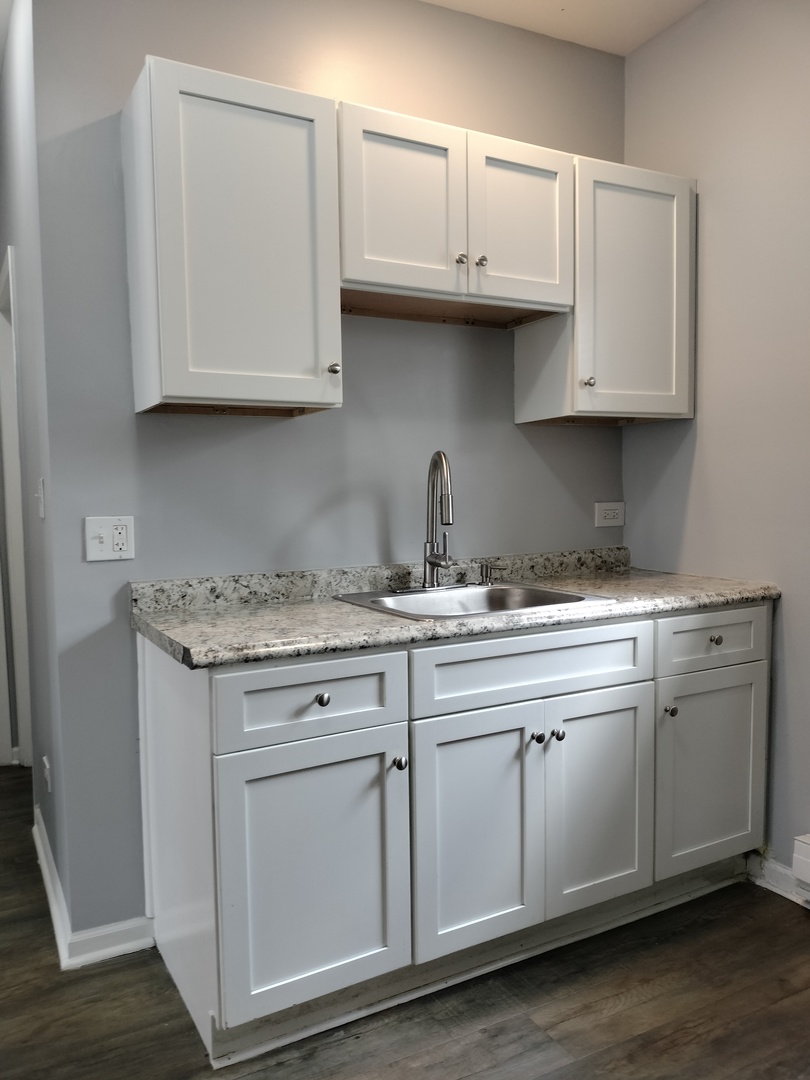 6601 South Green Street, Unit 8211 Chicago, IL 60621 - Photo 4 of 12 a kitchen with white cabinets and a sink