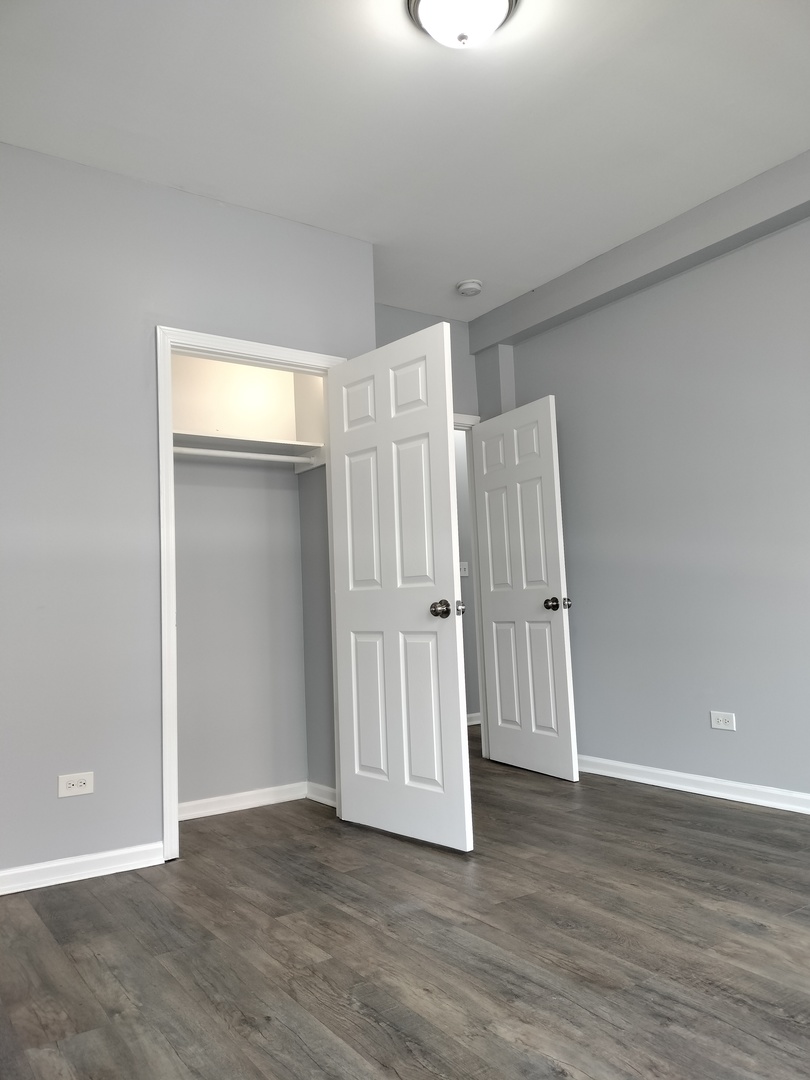 6601 South Green Street, Unit 8211 Chicago, IL 60621 - Photo 7 of 12 a view of an empty room with wooden floor