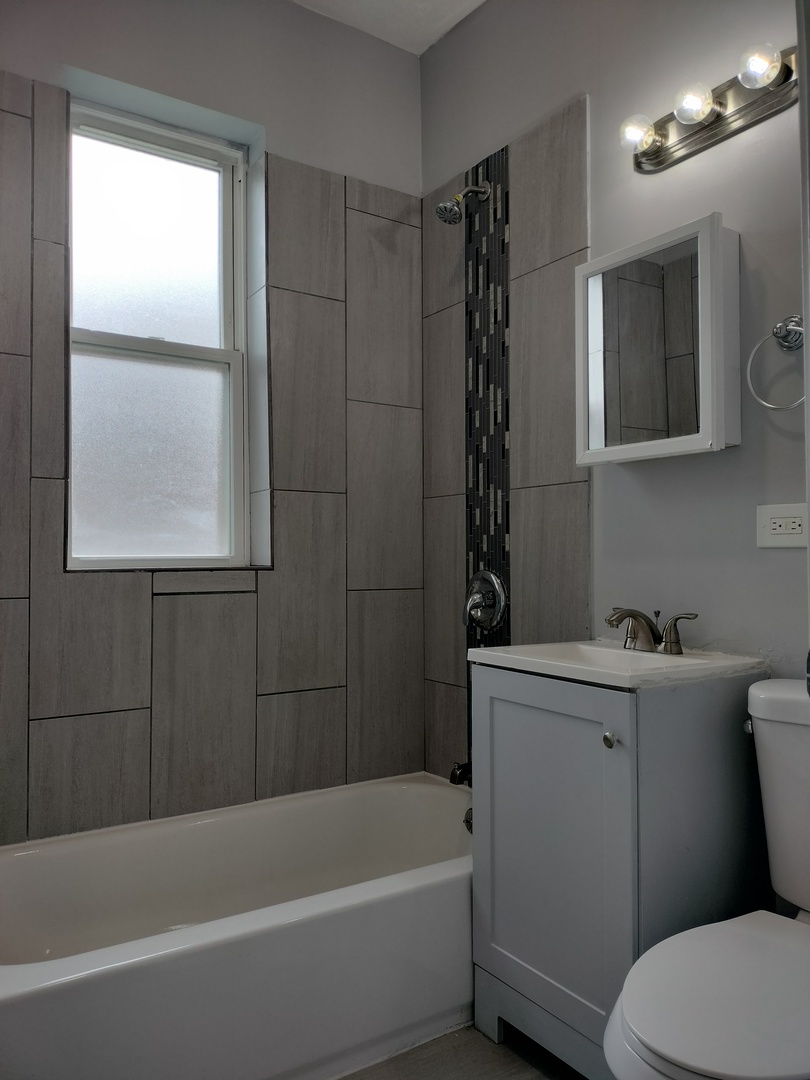 6601 South Green Street, Unit 8211 Chicago, IL 60621 - Photo 9 of 12 a bathroom with a sink a toilet and bathtub