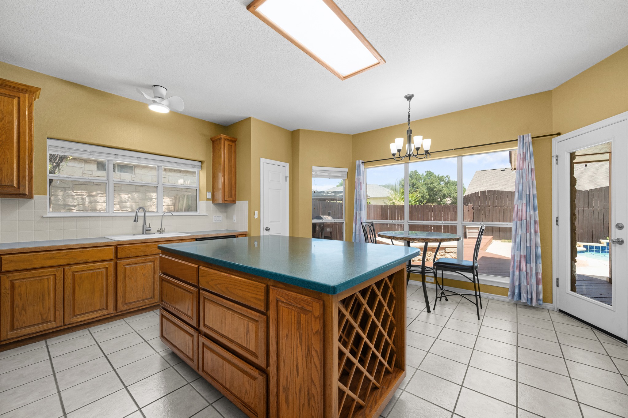 108 Thornwood Road Georgetown, TX 78628 - Photo 18 of 40 A well-appointed kitchen features a central island, ample cabinetry, and an eat-in area with a view of the backyard pool.