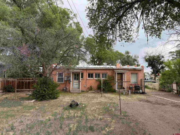 a view of a house with backyard and a tree