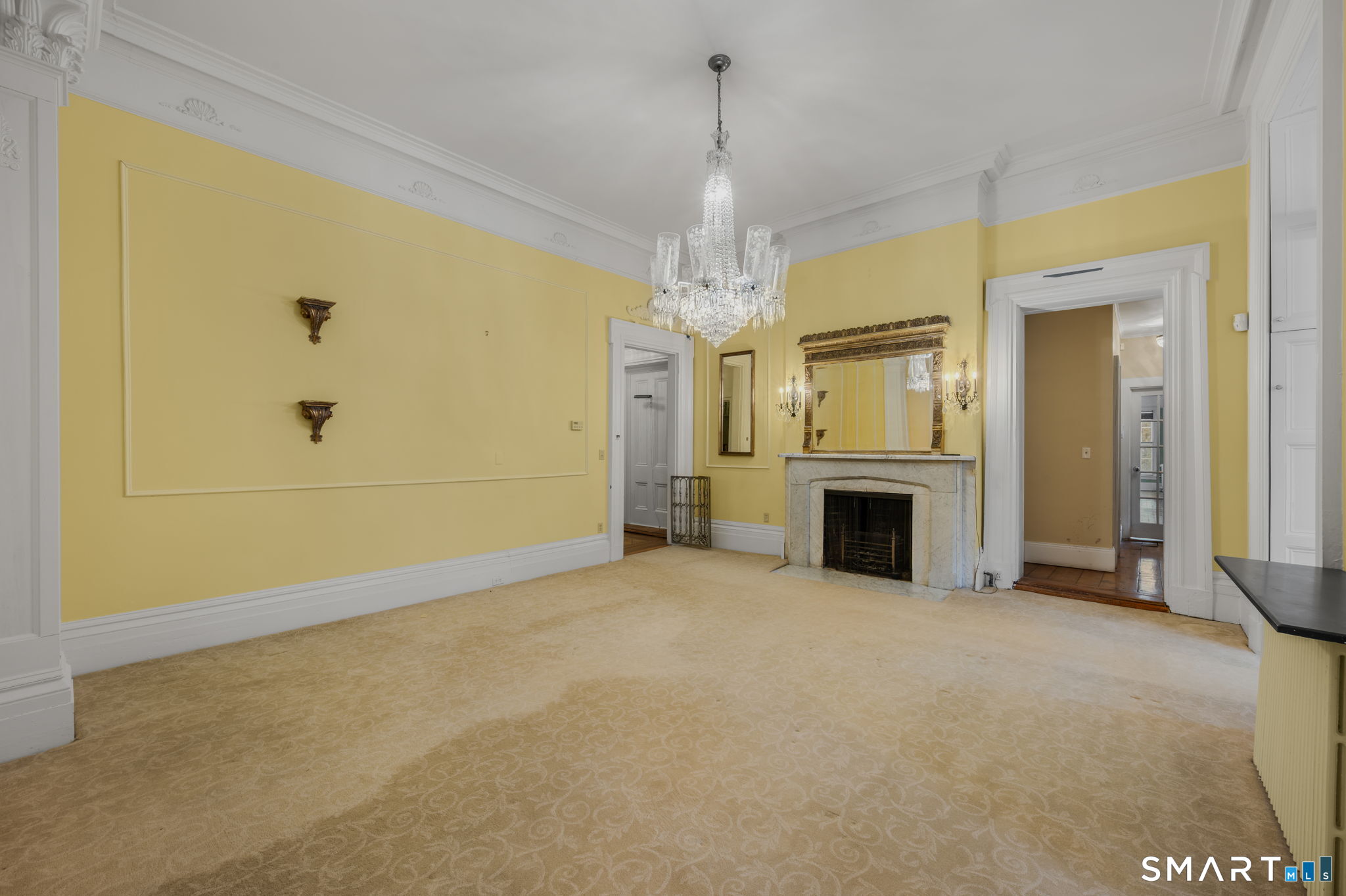 9 Lyme Street, Unit 2 Old Lyme, CT 06371 - Photo 21 of 29 an empty room with fireplace and chandelier