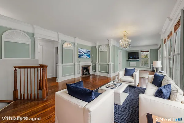 an empty room with fireplace and chandelier