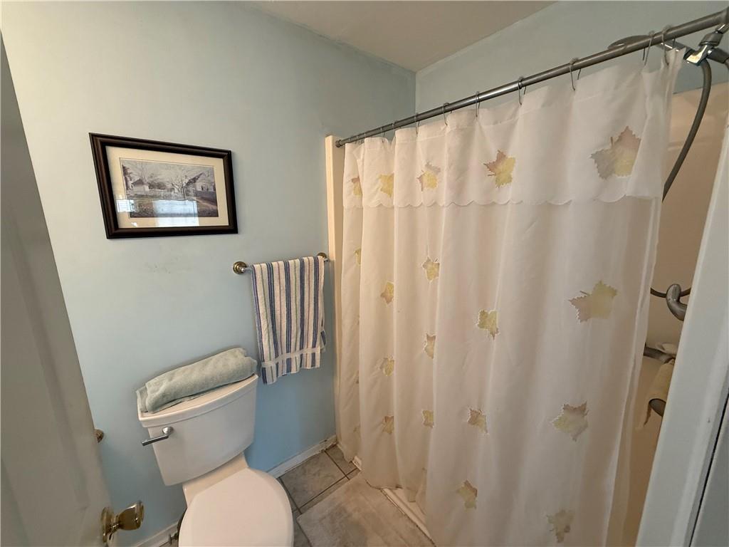 111 Fulton Lane Indiana, PA 15701 - Photo 9 of 20 a white toilet sitting next to a shower curtain