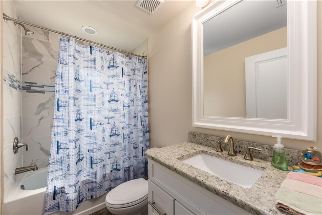 4833 Southeast Pilot Way Stuart, FL 34997 - Photo 29 of 37 a bathroom with a granite countertop sink toilet a mirror and shower curtain