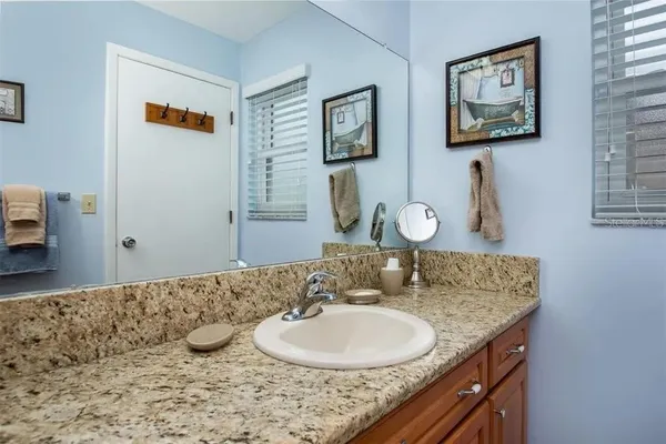 a bathroom with a granite countertop sink and a mirror