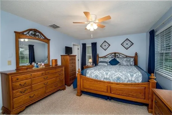 a bedroom with a large bed and a chandelier