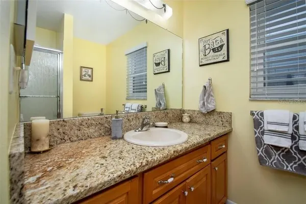 a bathroom with a granite countertop sink and a mirror