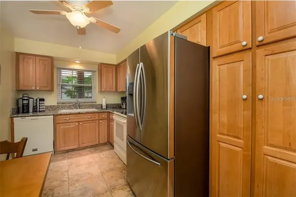 a kitchen with stainless steel appliances granite countertop a refrigerator and a sink