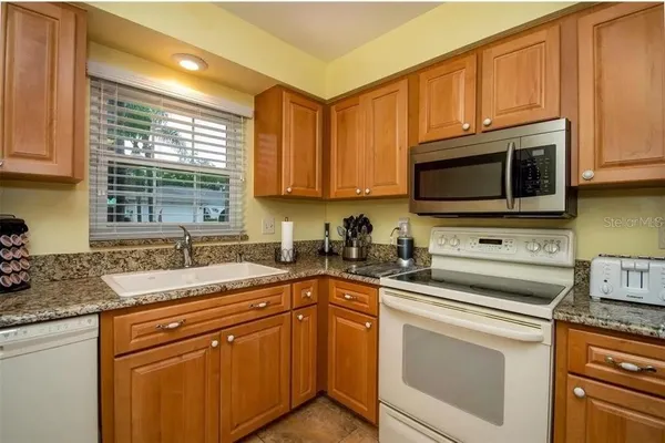 a kitchen with stainless steel appliances granite countertop a sink a stove a microwave and cabinets