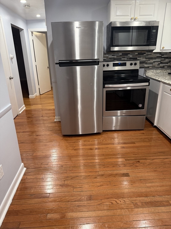 7 Champlain Road, Unit 1 Salem, MA 01970 - Photo 6 of 11 a view of a kitchen with stainless steel appliances and wooden floor