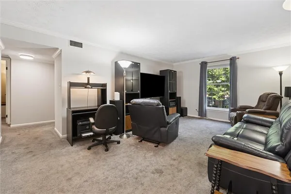 a view of a livingroom with workspace and a window