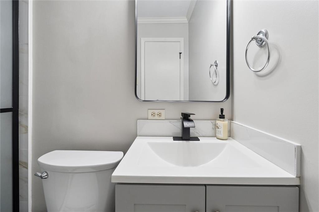 6700 Roswell Road, Unit 31B Atlanta, GA 30328 - Photo 17 of 32 a bathroom with a sink a toilet and a mirror