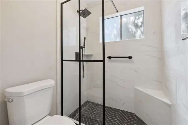 a bathroom with a toilet and a shower