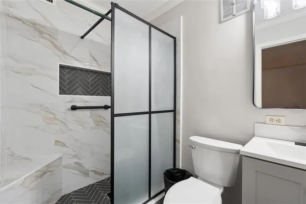 a bathroom with a toilet and a shower